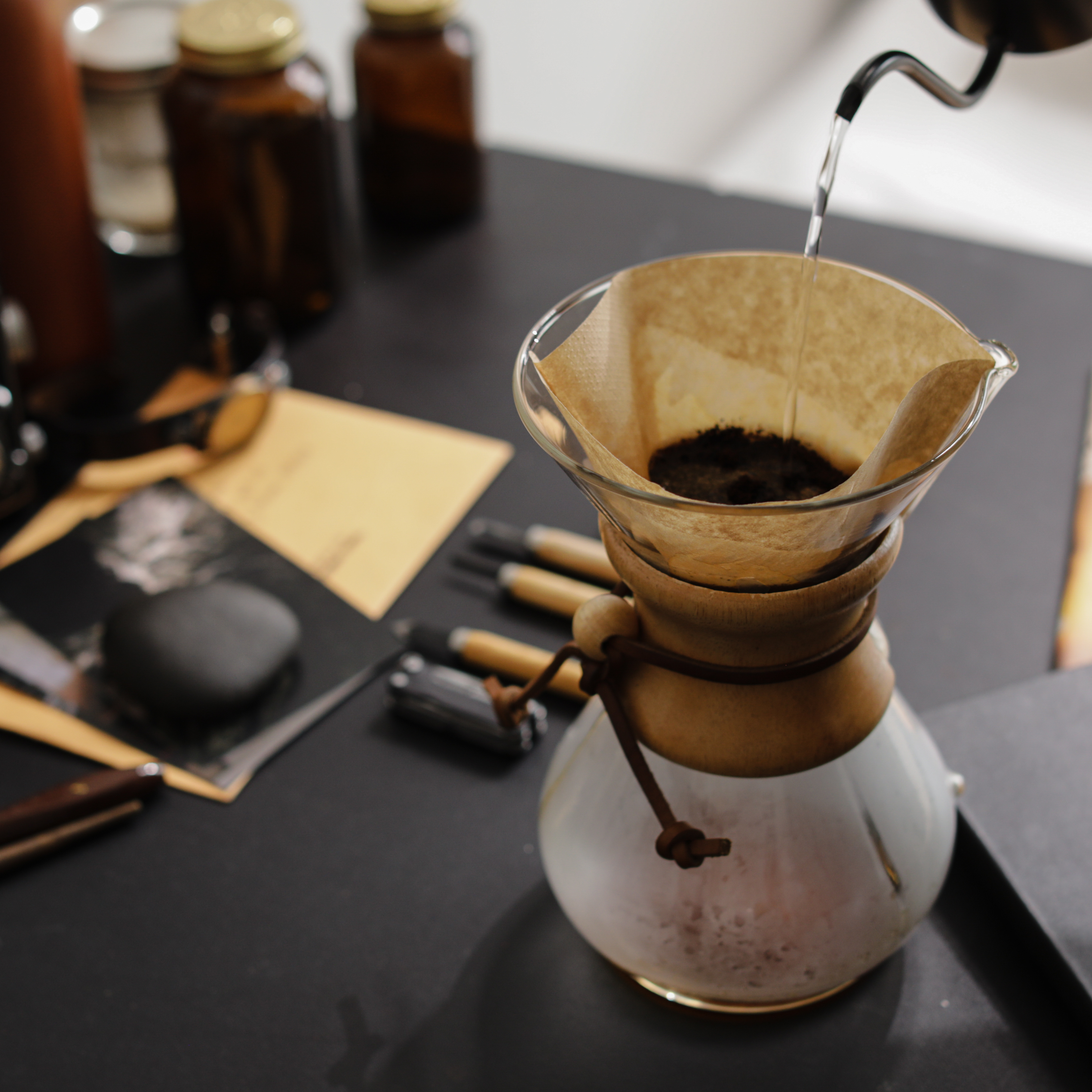 Pouring hot water over ground coffee in a Chemex to brew a delicious cup of coffee.